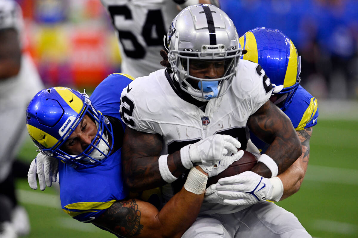 Las Vegas Raiders running back Ameer Abdullah, center, is tackled by Los Angeles Rams linebacke ...