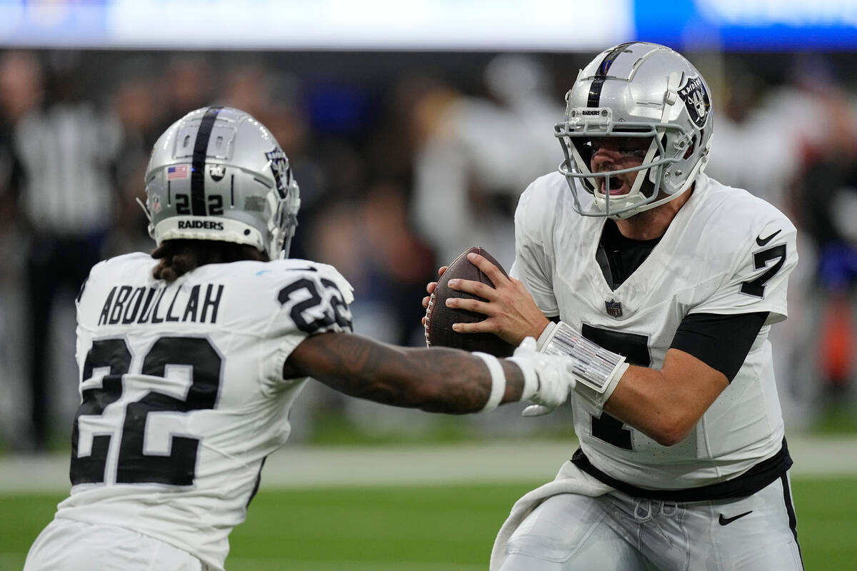 Las Vegas Raiders quarterback Brian Hoyer prepares to hand off to Ameer Abdullah (22) during th ...