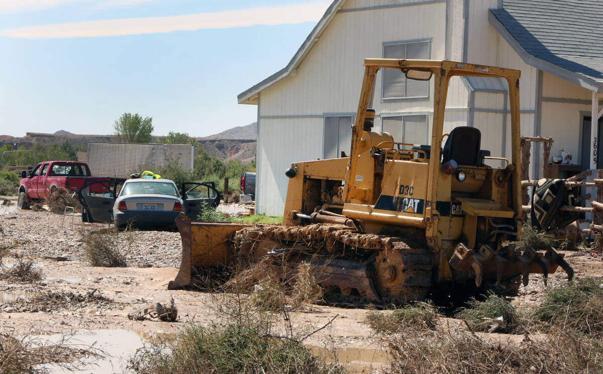 Flood damaged bulldozer, car and pickup truck are seen on Andy Shakespear's driveway, on Saturd ...