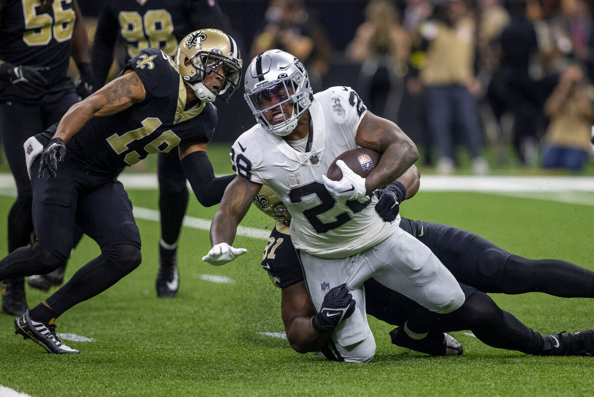 Raiders running back Josh Jacobs (28) is tackled by New Orleans Saints defensive tackle Kentavi ...