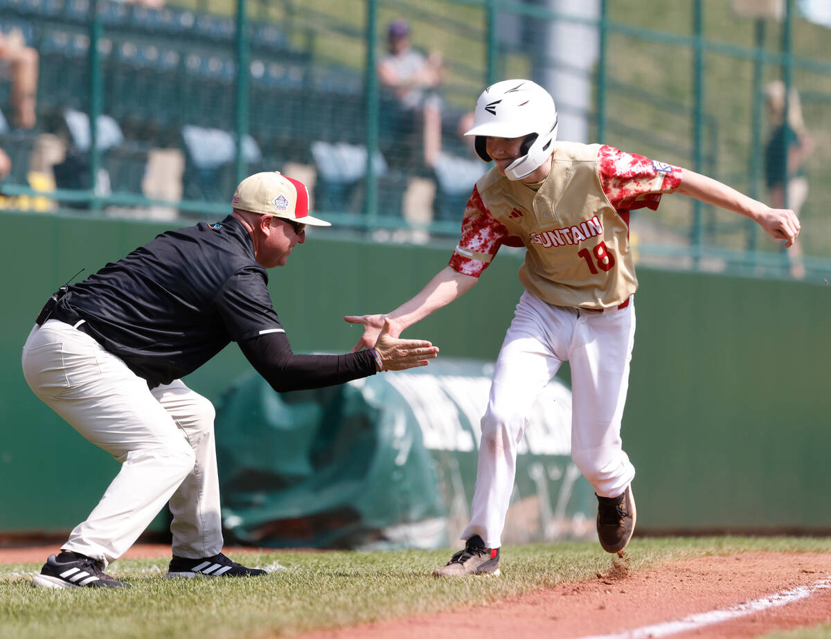 The Henderson All-Stars centerfield Nolan Gifford celebrates with assistant coach Arlie Daniel ...