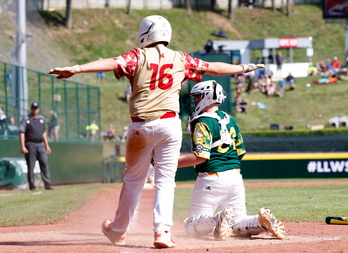 The Henderson All-Stars third baseman Logan Levasseur claims he is safe after scoring as Fargo, ...