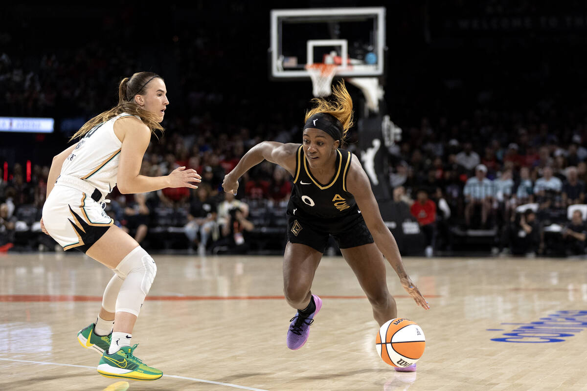 Aces guard Jackie Young dribbles while New York Liberty guard Sabrina Ionescu defends during a ...