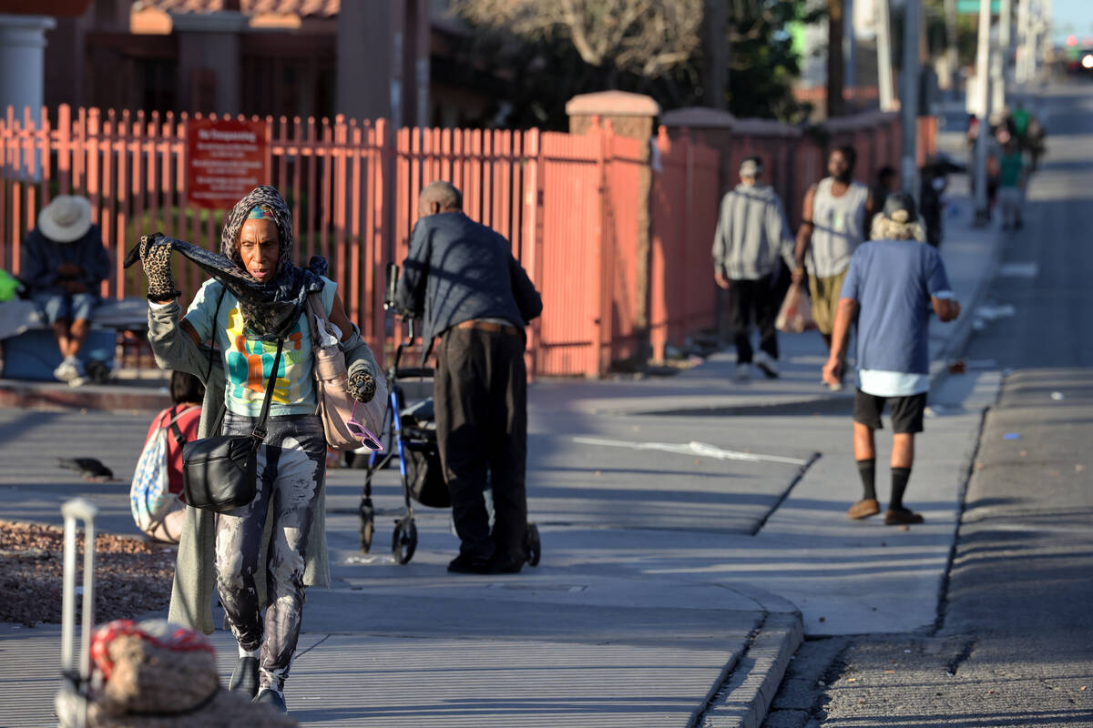 People congregate on Main Street outside the Catholic Charities campus Tuesday, Aug. 22, 2023, ...