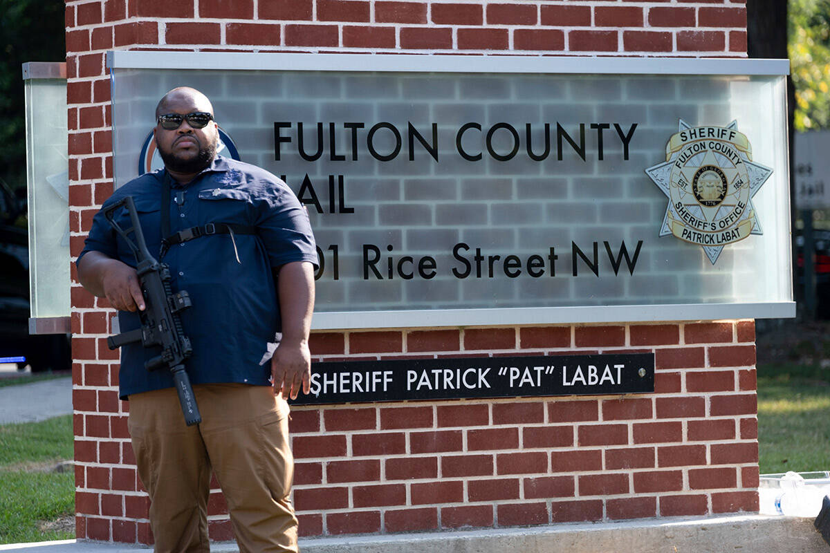 An official stands guard in front of the Fulton County Jail in Atlanta on Thursday, Aug. 24, 20 ...