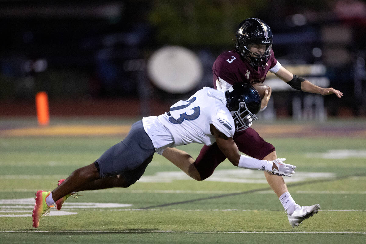 Faith Lutheran quarterback Garyt Odom (3) is brought down by Desert Pines cornerback Darius McC ...