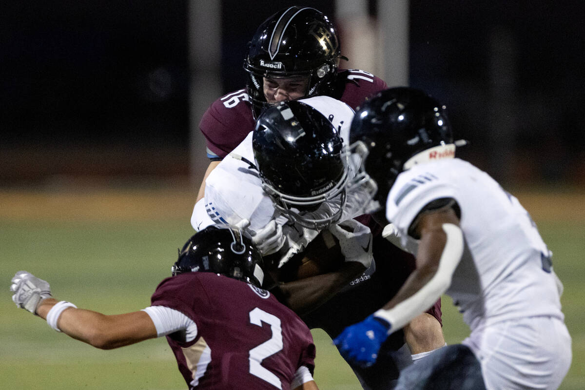 Faith Lutheran fast safety Matthew Mason (16) tackles Desert Pines running back Greg Burrell (5 ...