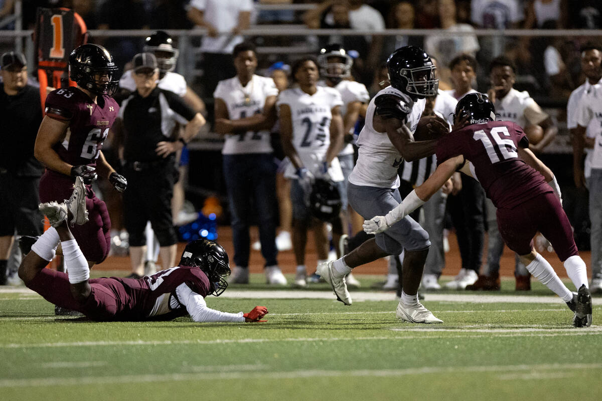 Desert Pines running back Greg Burrell (5) weaves between Faith Lutheran players before scoring ...