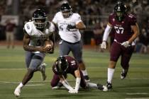 Desert Pines running back Greg Burrell (5) evades tackle from Faith Lutheran fast safety Matthe ...
