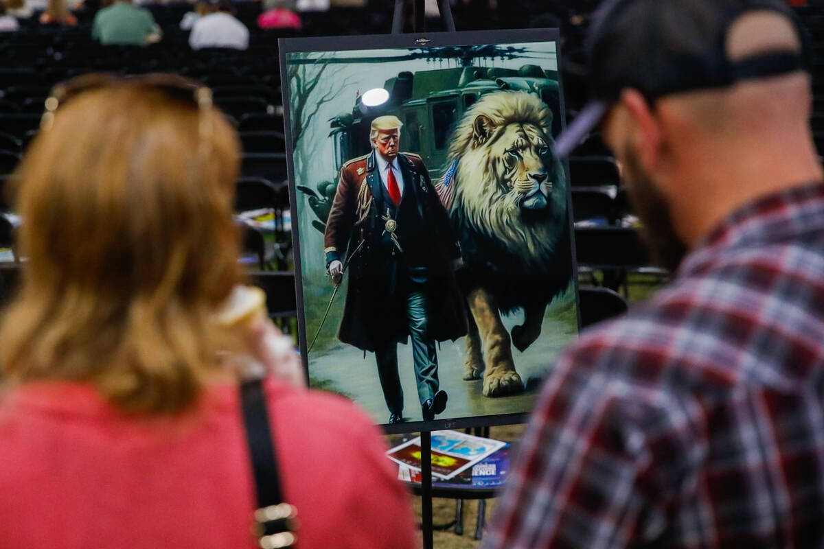A couple admires an artist’s rendition of Donald Trump at the ReAwaken America Tour on F ...