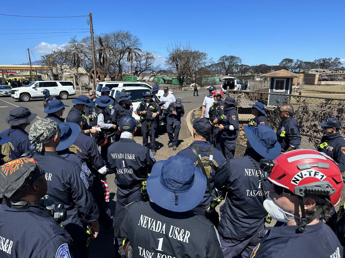 Nevada Task Force-1 members listen to instructions during their search for remains in Lahaina o ...