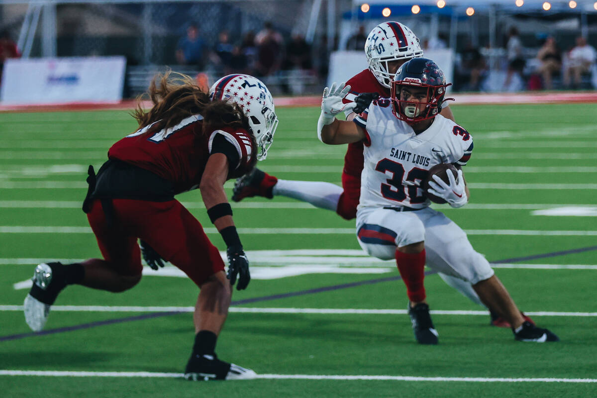 A St. Louis player (33) braces for impact as Liberty defensive back Lamese Gora (31) comes at h ...