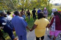 Residents gather for a prayer near the scene of a mass shooting at a Dollar General store, Satu ...