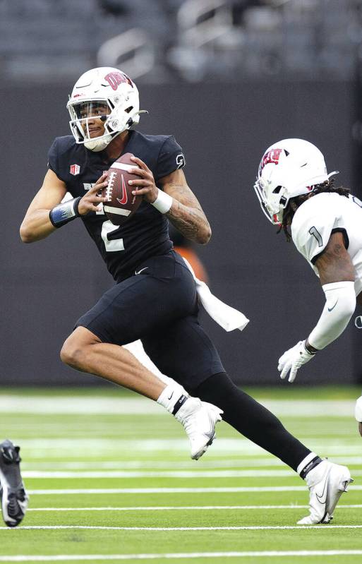 Quarterback Doug Brumfield (2) looks to pass while defensive backs Daego Albert (40) and Jalen ...