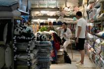 A vendor waits for customers at a store in Beijing, Thursday, July 27, 2023. (AP Photo/Ng Han ...