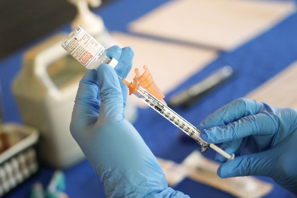 A nurse prepares a syringe of a COVID-19 vaccine at an inoculation station in Jackson, Miss., i ...