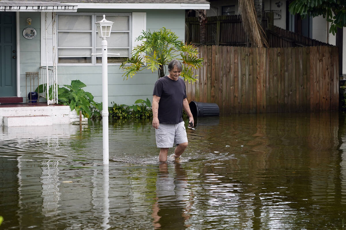 Don Hawthorne walks across his flooded yard in unincorporated Pinellas County, Fla., after the ...