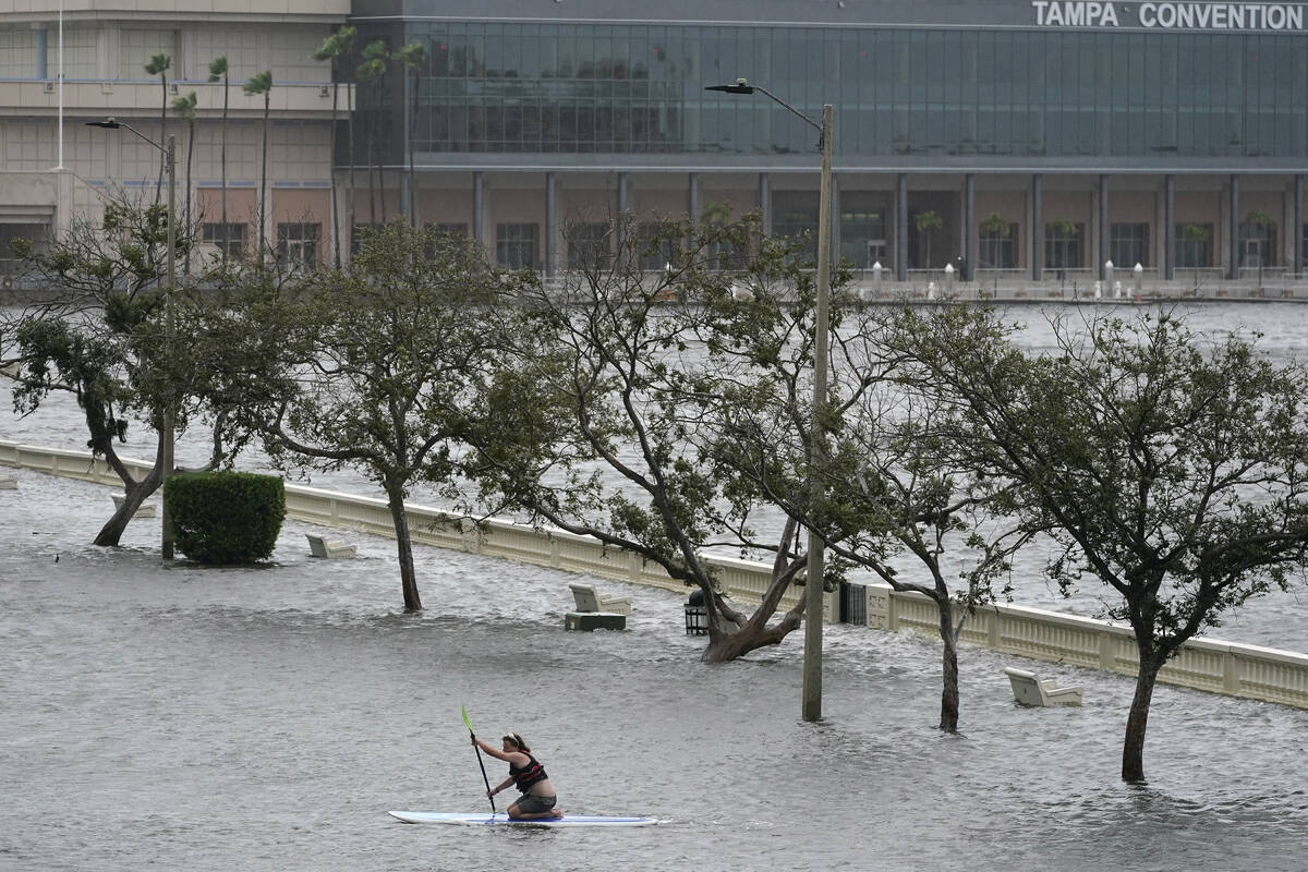 Zeke Pierce rides his paddle board down the middle of a flooded Bayshore Blvd in downtown in Ta ...
