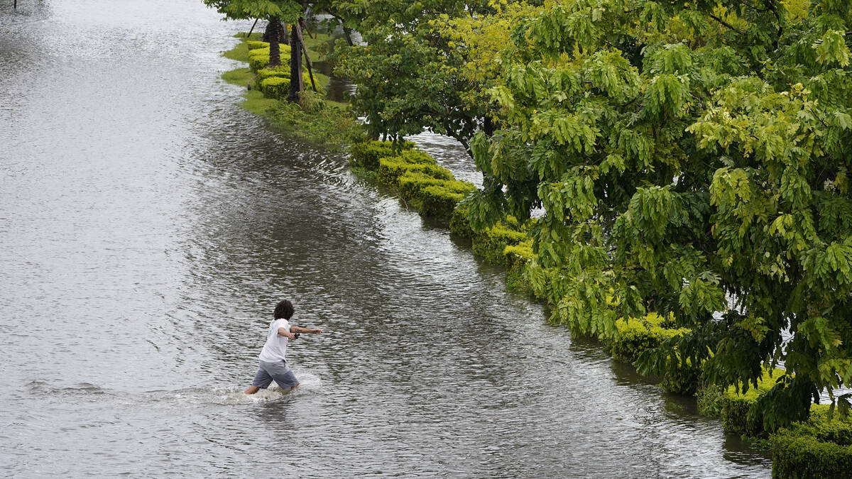 A man runs across flooded Bayshore Blvd., from the storm surge associated with Hurricane Idalia ...
