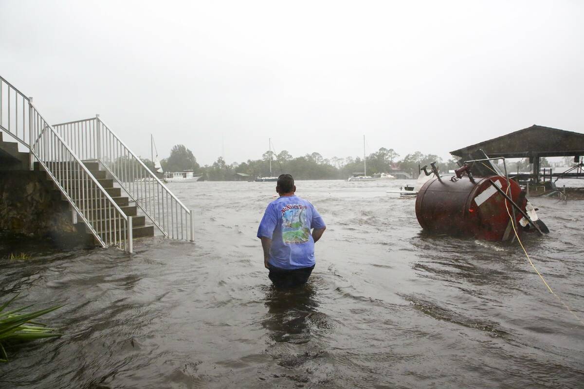 Daniel Dickert wades through water after the Steinhatchee River flooded on Wednesday, Aug. 30, ...