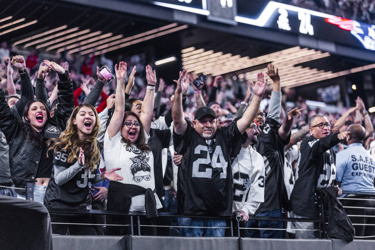 Raiders fans celebrate after a late-game score against the New England Patriots during the seco ...