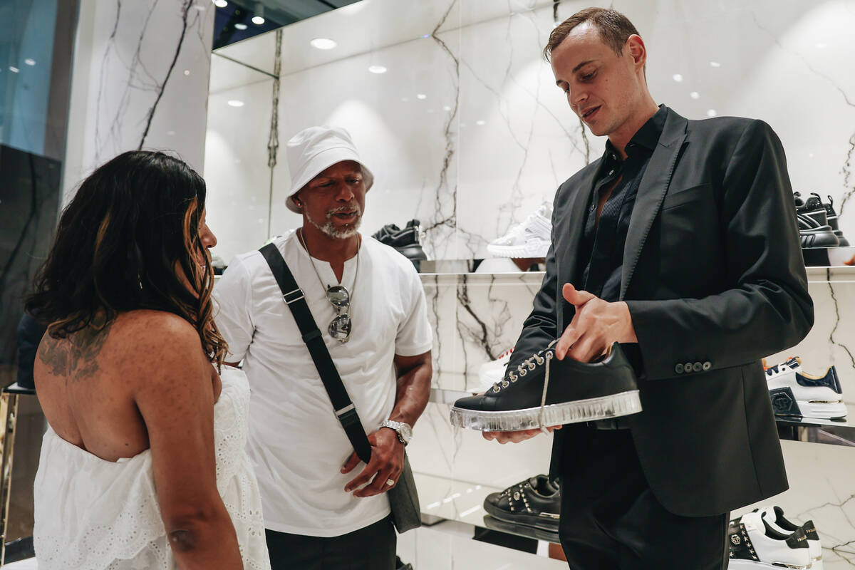 A sales associate shows off a pair of shoes at the Philipp Plein boutique inside of the Shops a ...