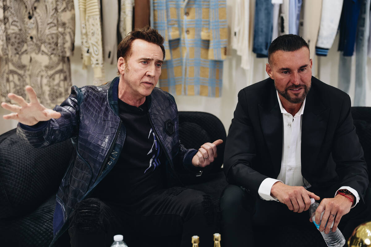 Nicolas Cage, left, speaks to the media while seated next to designer Philipp Plein during a gr ...