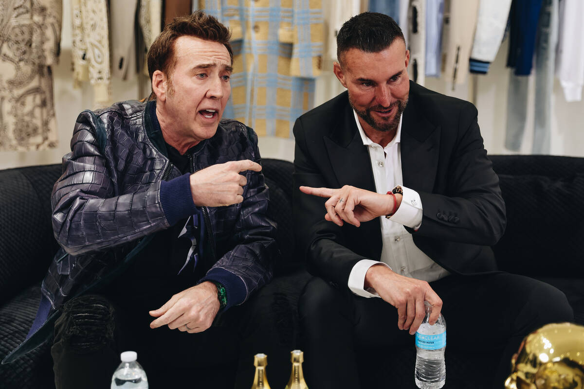 Nicolas Cage, left, speaks to the media while seated next to designer Philipp Plein during a gr ...