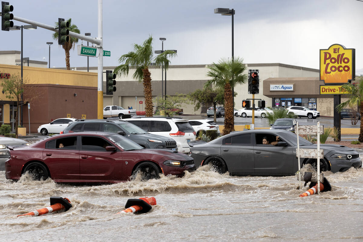 Motorists watch flash flood waters as they pass through East Sahara Avenue and South Eastern Av ...