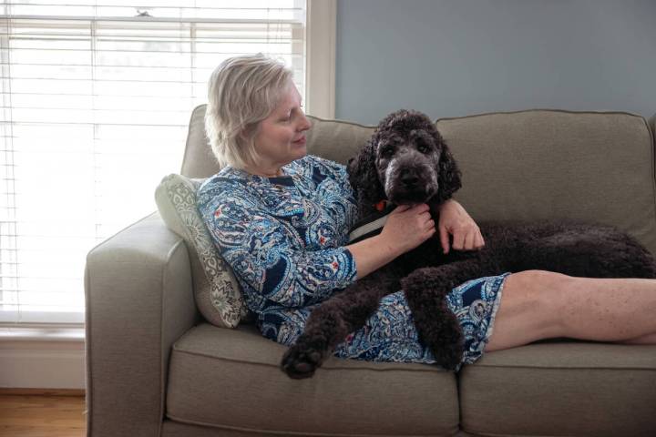 Sally Nix lies on the couch with her service dog, Jon Snow, at home in Statesville, North Carol ...