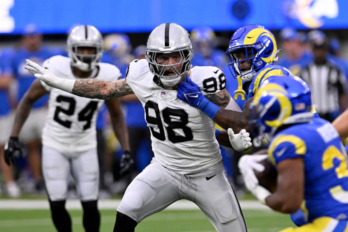 Las Vegas Raiders defensive end Maxx Crosby (98) eyes Los Angeles Rams running back Ronnie Rive ...