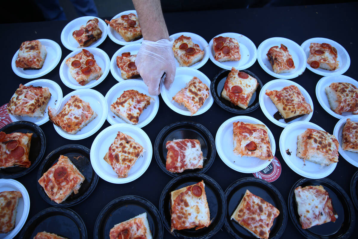 Pizza slices are served at the Flour & Barley Brick Oven Pizza booth during the Las Vegas Pizza ...