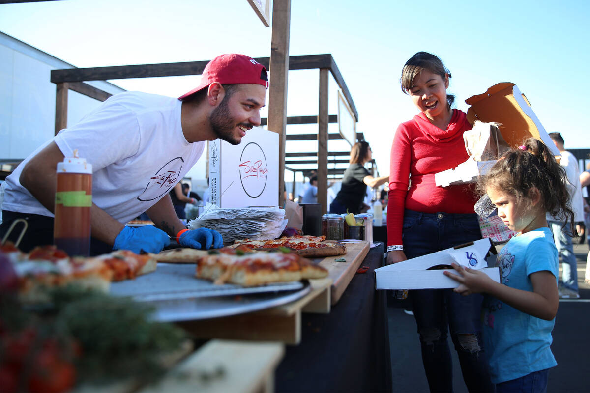 Enzo Esposito, left, executive pizza chef for Side Piece Pizza, asks Wenda Swords and her daugh ...