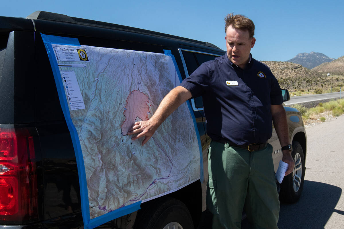 Jeremy Kiesling, the incident commander trainee with Great Basin Team 7, indicates on a map an ...