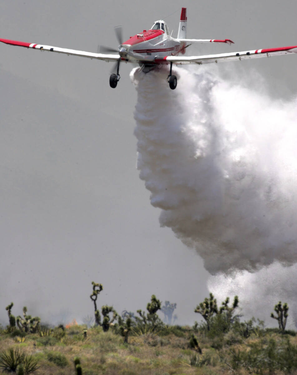 A plane makes a water drop at the fire line at Goodsprings. (Las Vegas Review-Journal) Ne ...
