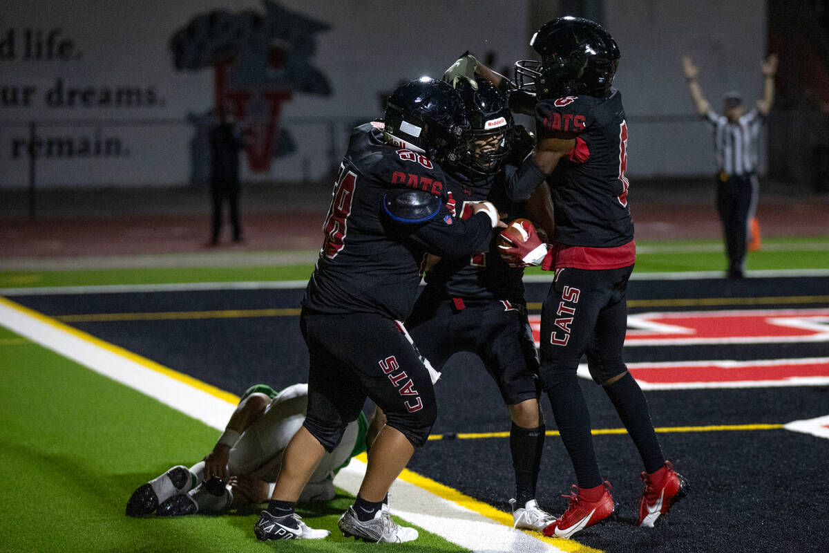 Las Vegas players congratulate their Julian Torres, center, on his touchdown during the second ...