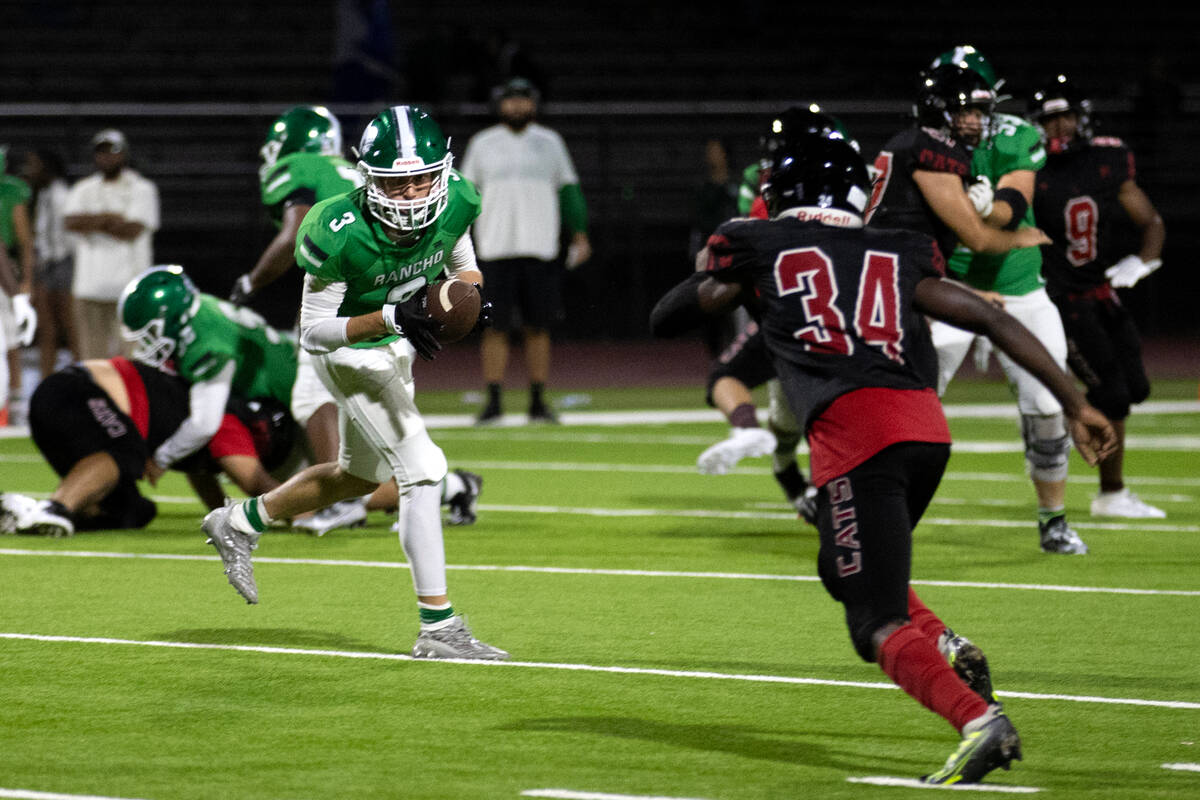 Rancho's Braedan Linkins (3) pivots with his catch before running while Las Vegas linebacker Ni ...