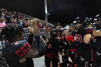 Las Vegas running back Torrell Harley (7) holds up his team’s trophy while leading them ...