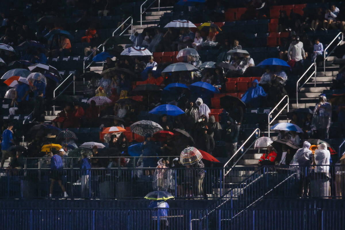 Fans wait for the rain to mellow out before the beginning of Bishop Gorman’s game agains ...