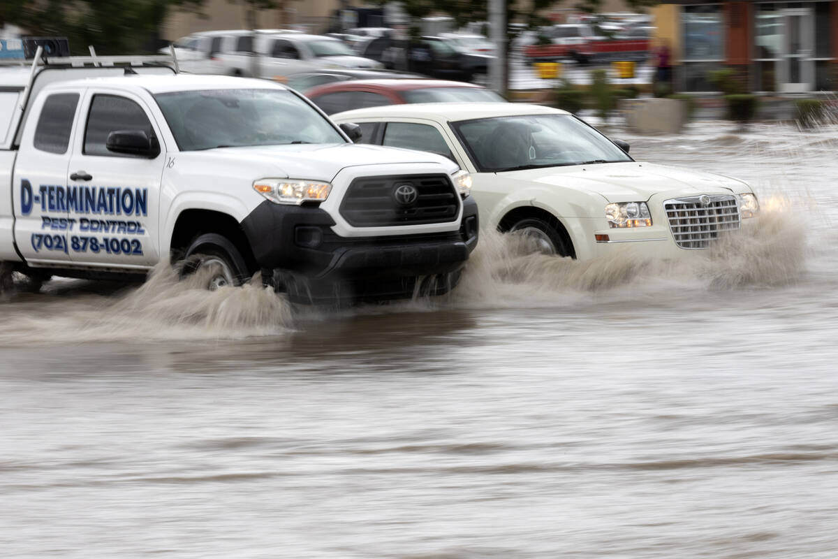 Traffic plows through flash flooding at East Sahara Avenue and South Eastern Avenue on Friday, ...