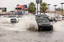 A vehicle makes a wake taller than itself while traveling down South Eastern Avenue on Friday, ...