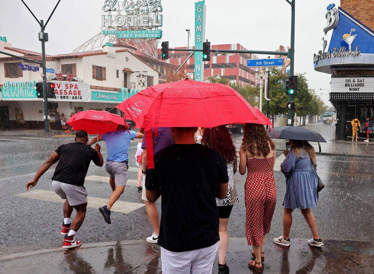A tour group braves the rain on East Fremont Street in downtown Las Vegas on Friday, Sept. 1, 2 ...