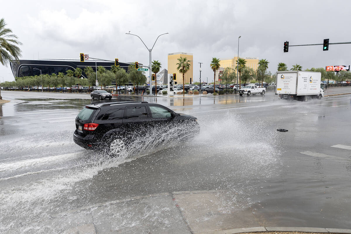 A vehicle passes through flood waters at West Russell Road and Polaris Avenue on Saturday, Sept ...