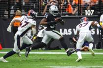 Raiders running back Brandon Bolden (34) runs the ball between Denver Broncos linebacker Josey ...