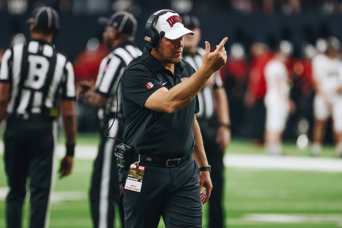 UNLV head coach Barry Odom stands on the field during a weather delay after rain leaked into Al ...