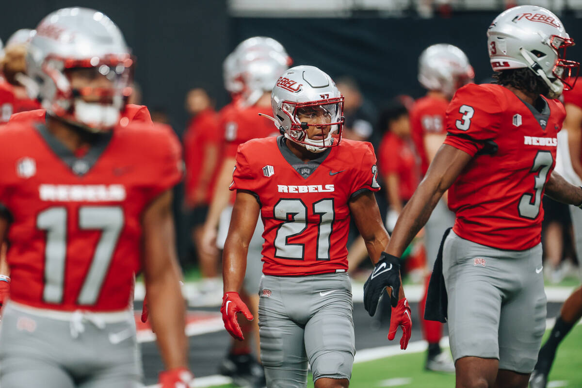 UNLV wide receiver Jacob De Jesus (21) walks on the field with his teammates for warm ups befor ...