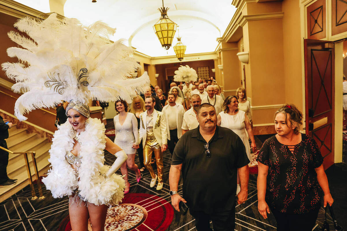 Showgirls walk 250 couples into the Octavius Ballroom for a vow renewal ceremony at Caesars Pal ...