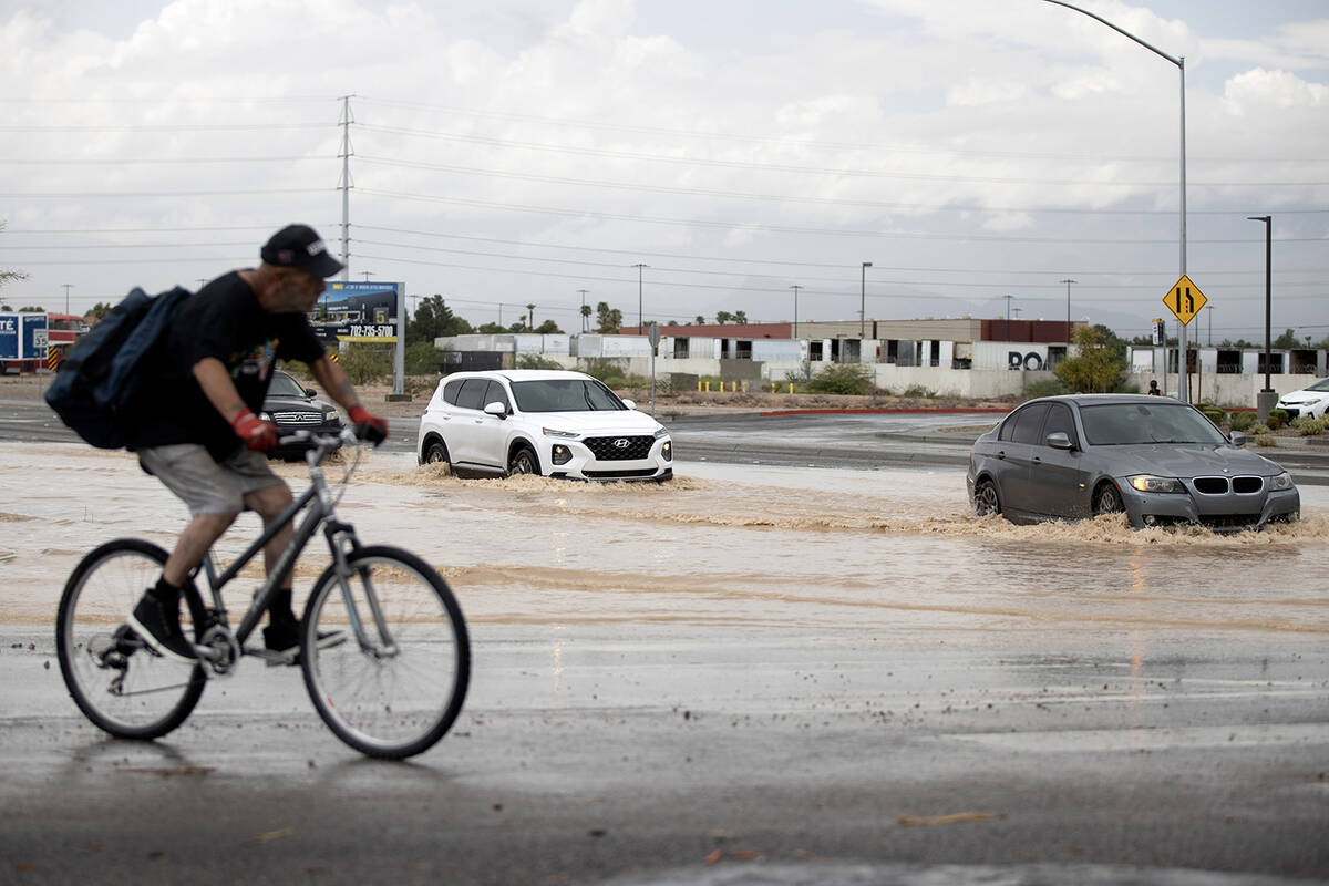 Traffic navigates flood waters at West Sunset Road and South Decatur Boulevard on Saturday, Sep ...