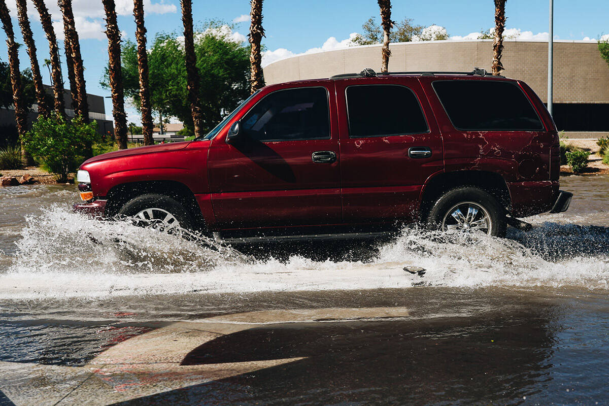 A car drives through residual flooding from recent rainfall on North Mojave Road on Sunday, Sep ...