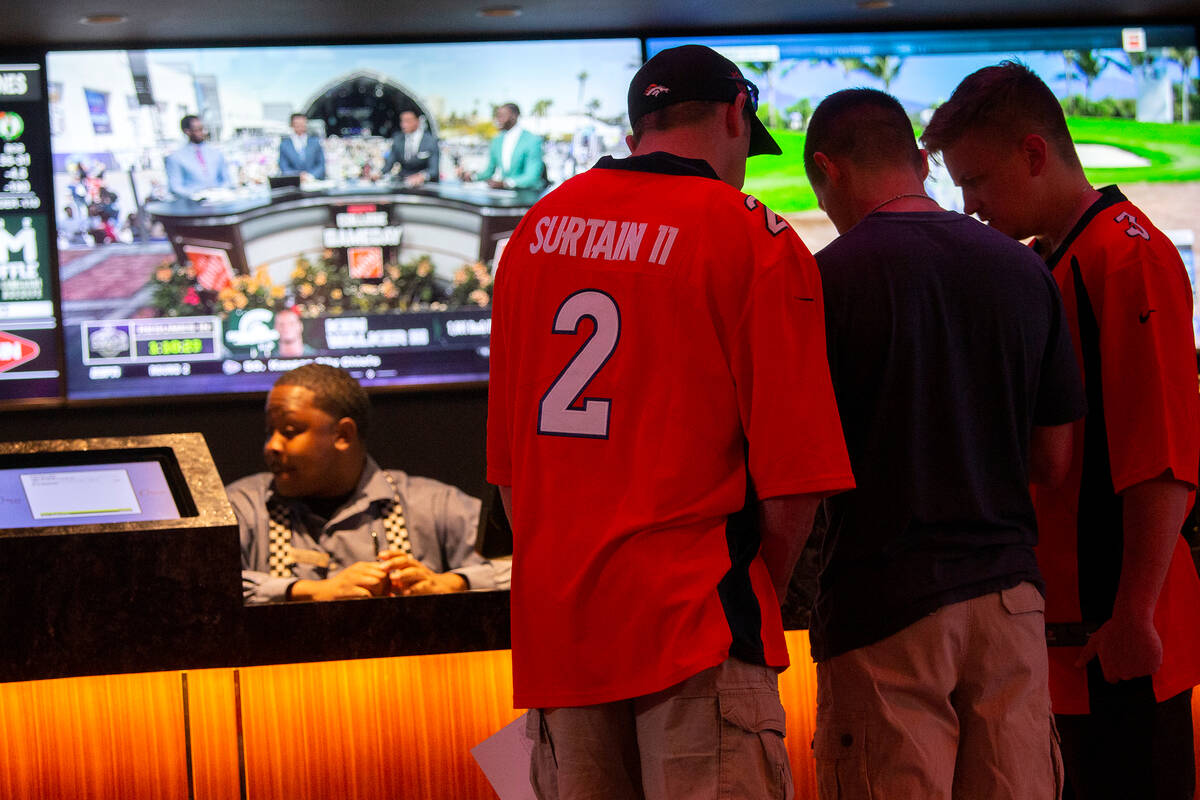 Sports bettors wear NFL jerseys while placing bets at Circa on Friday, April 29, 2022, in Las V ...